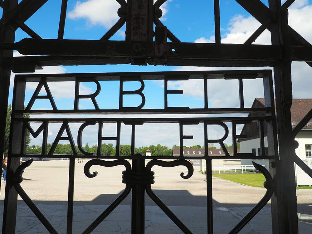 The sign for Dachau Concentration Camp reads "arbeit macht frei" meaning "work makes you free." | via Autumn All Along